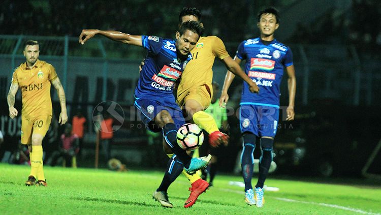 Hendro Siswanto (tengah) saat berebut bola dengan pemain Bhayangkara FC. Copyright: © Ian Setiawan/INDOSPORT