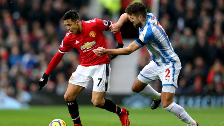 Penyerang Manchester United Alexis Sanchez saat berduel dengan pemain Huddersfield Town. Copyright: © Getty Images