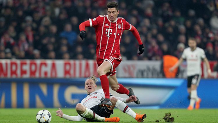 Robert Lewandowski coba dijatuhkan oleh pemain Besiktas. Copyright: © Getty Images