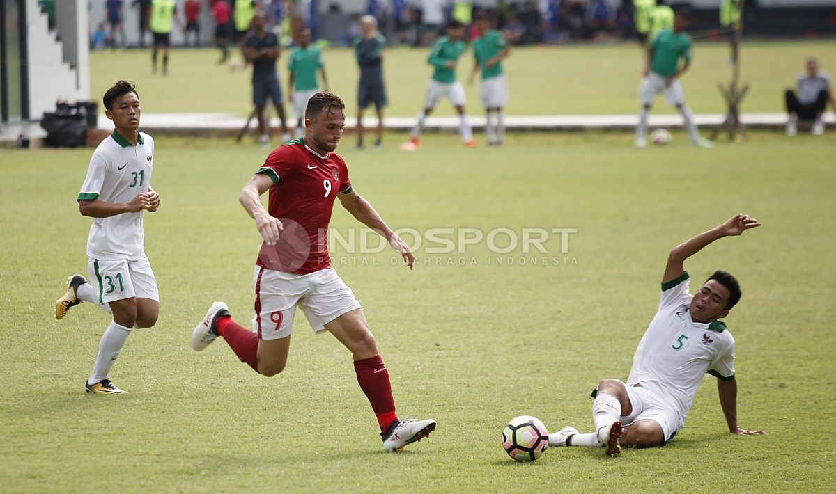 Ilija Spasojevic (tengah) berupaya melewati hadangan bek Timnas U-19, Nurhidayat Haji Haris. Copyright: © Herry Ibrahim/INDOSPORT