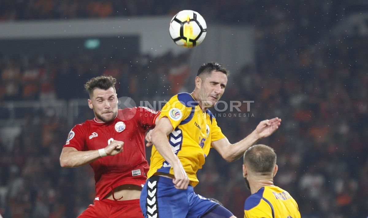 Marko Simic melakukan duel udara dengan salah satu pemain Tampines Rovers. Copyright: © Herry Ibrahim/INDOSPORT