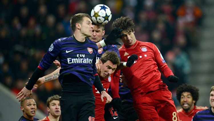 Duel udara Arsenal melawan Bayern Munchen pada laga 16 besar Liga Champions 2012-13. Copyright: © Getty Images