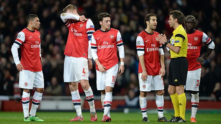 Pemain Arsenal tertunduk lesu gagal lolos 8 besar melawan Bayern Munchen 2013-14. Copyright: © Getty Images
