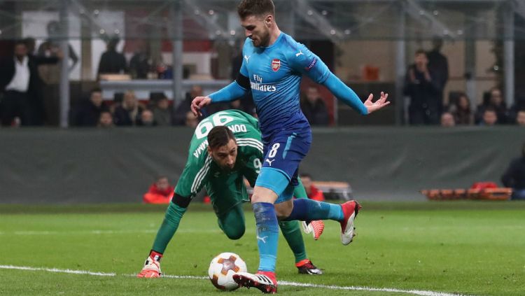 Aaron Ramsey kelabui Donnarumma saat cetak gol kedua Arsenal. Copyright: © GettyImages