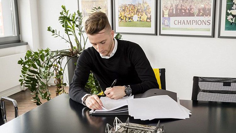 Marco Reus menandatangani kontak. Copyright: © Borussia Dortmund