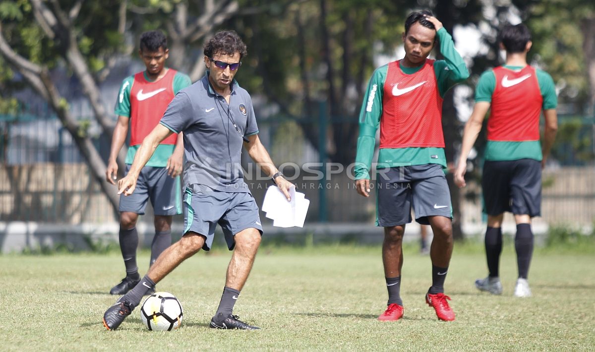 Pelatih Luis Milla mencontohkan operan kepada pemainnya. Copyright: © Herry Ibrahim/INDOSPORT