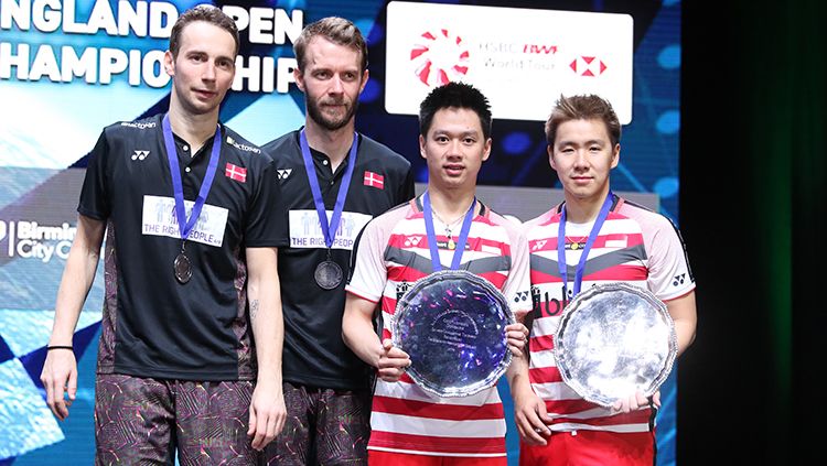 Pasangan Kevin/Marcus foto bersama dengan pasangan Denmark Boe/Mogensen di podium juara All England. Copyright: © INDOSPORT