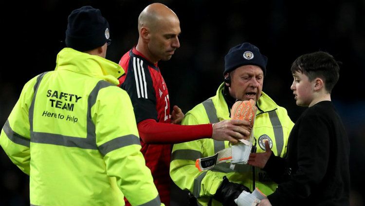 Willy Caballero memberikan sarung tangannya ke anak yang masuk ke lapangan. Copyright: © The Sun