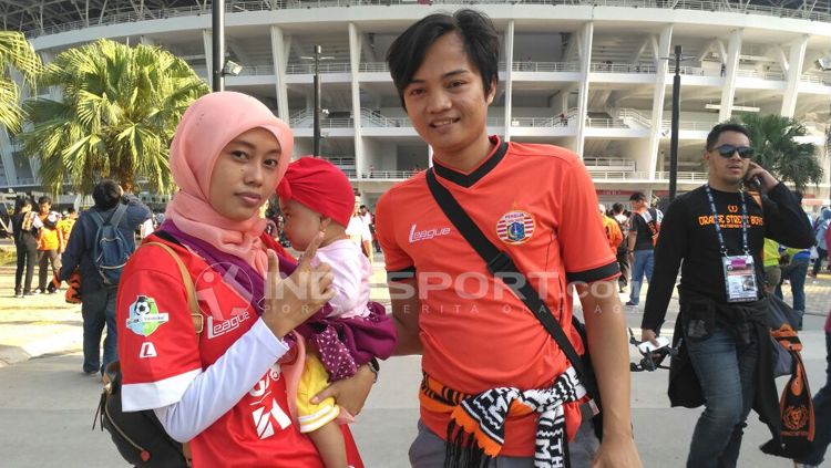 Keluarga kecil asal Cikarang datang mendukung Persija dengan membawa bayi berusia delapan bulan. Copyright: &copy; Petrus Manus Da' Yerimon/INDOSPORT