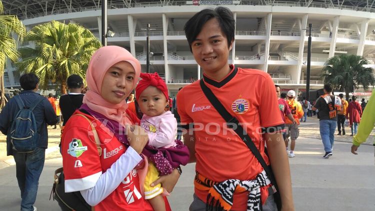 Keluarga kecil asal Cikarang datang mendukung Persija dengan membawa bayi berusia delapan bulan. Copyright: &copy; Petrus Manus Da' Yerimon/INDOSPORT
