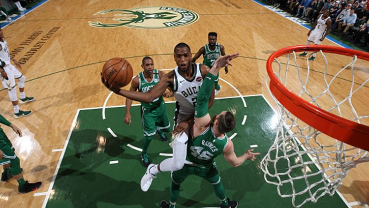 Khris Middleton berusaha memasukan bola dengan melewati pemain Boston Celtics. Copyright: © Getty Images
