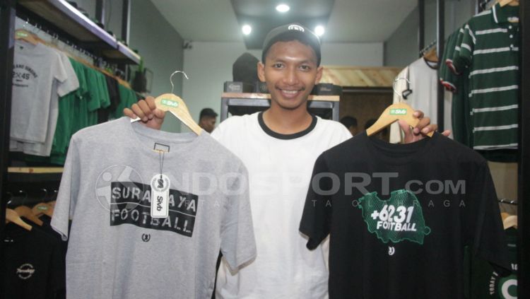 Firman menunjukkan dua kaus hasil desainnya. Copyright: &copy; Fitra Herdian Ariestianto/INDOSPORT