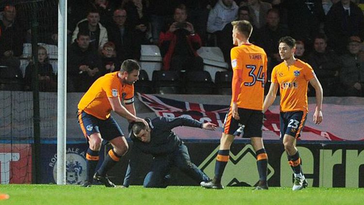 Pemain Oldham Athletic AFC menghentikan penyusup lapangan yang hendak menyerang wasit. Copyright: © Manchester Evening News