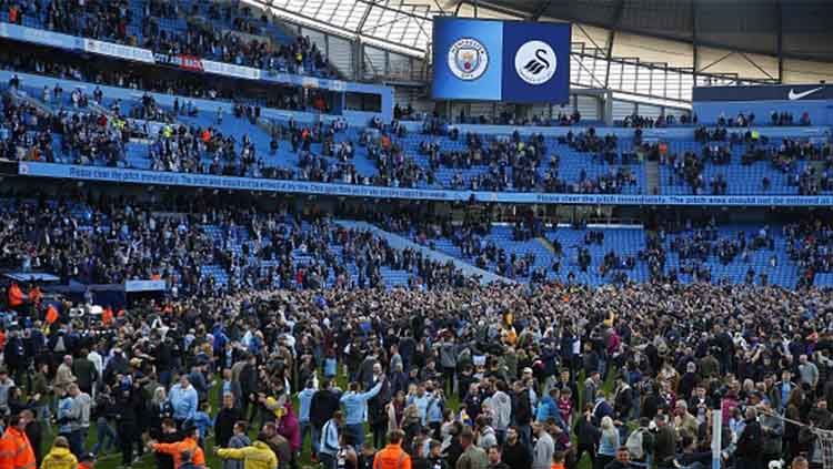 Para pendukung Man City turun ke lapangan merayakan kemenangan.  . Copyright: Â© INDOSPORT