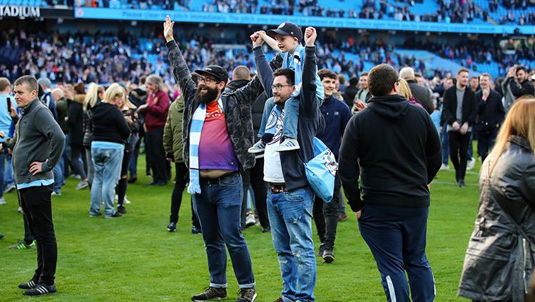 Para pendukung Man City turun ke lapangan merayakan kemenangan.
. Copyright: © Getty Images