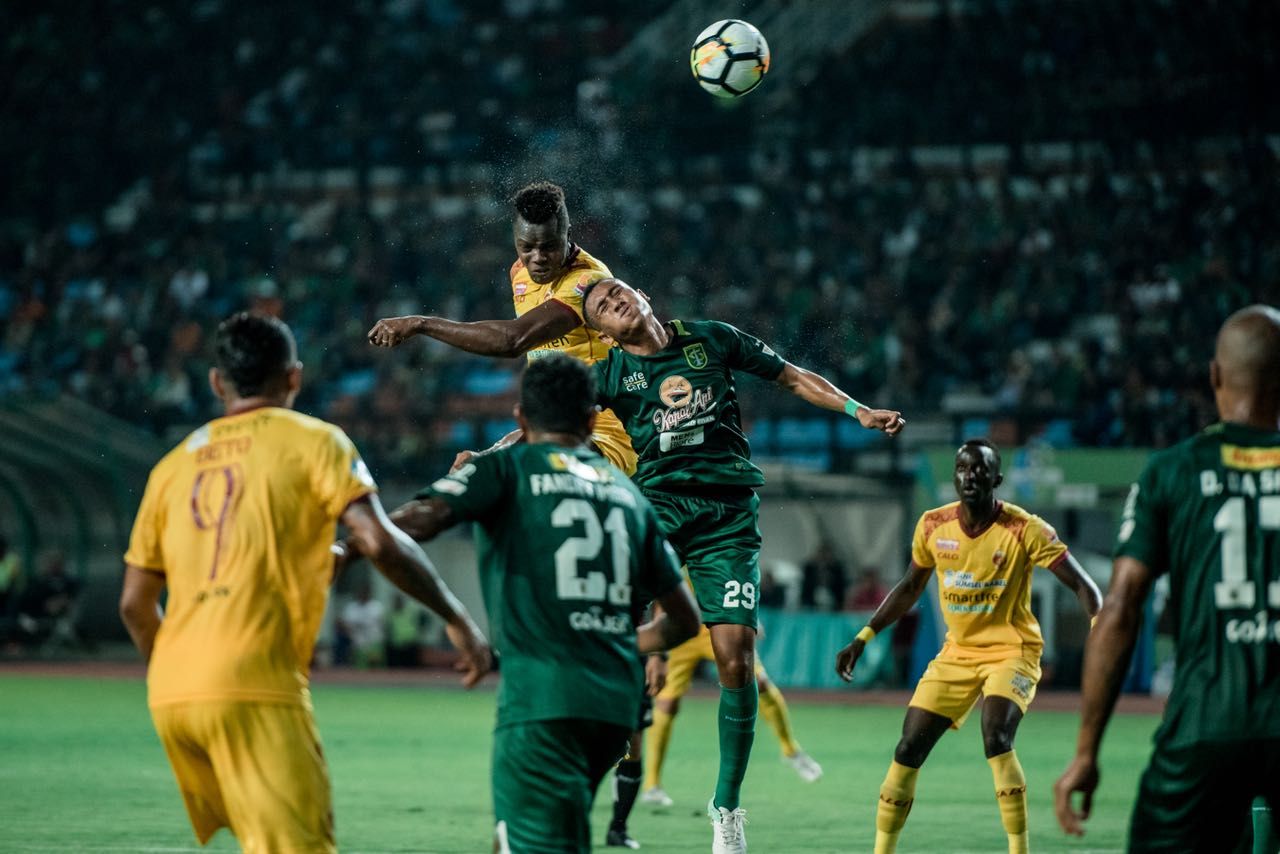 Aksi bek Persebaya, M. Syaifudin, saat menghalau pemain Sriwijaya FC. Copyright: © Media Persebaya