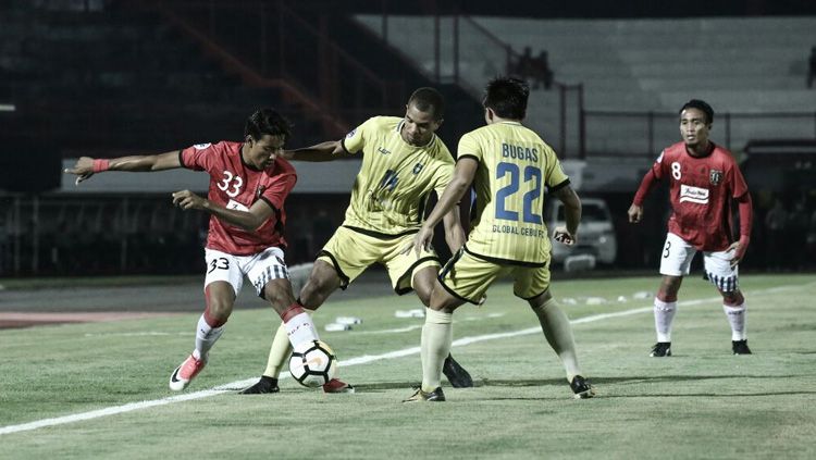 Salah satu pemain Bali United dikawal ketat dua pemain Global Cebu. Copyright: © Bali United