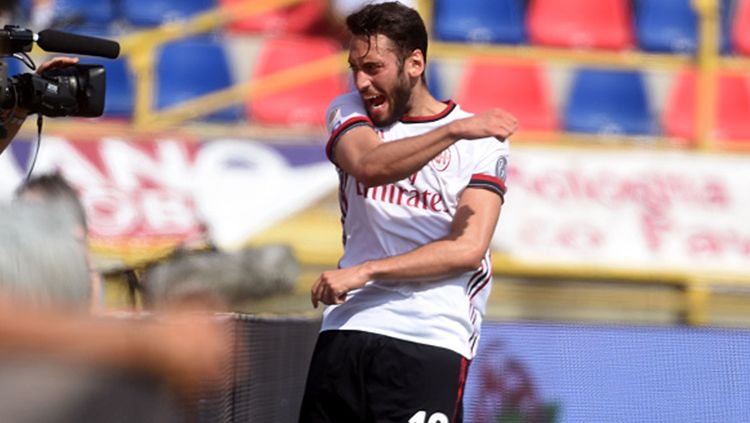Hakan Calhanoglu berselebrasi usai mencetak gol pembuka untuk AC Milan saat melawan Bologna. Copyright: © Getty Image