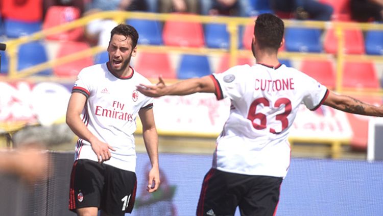 Hakan Calhanoglu (kiri) berselebrasi usai mencetak gol pembuka untuk AC Milan saat melawan Bologna. Copyright: © Getty Image