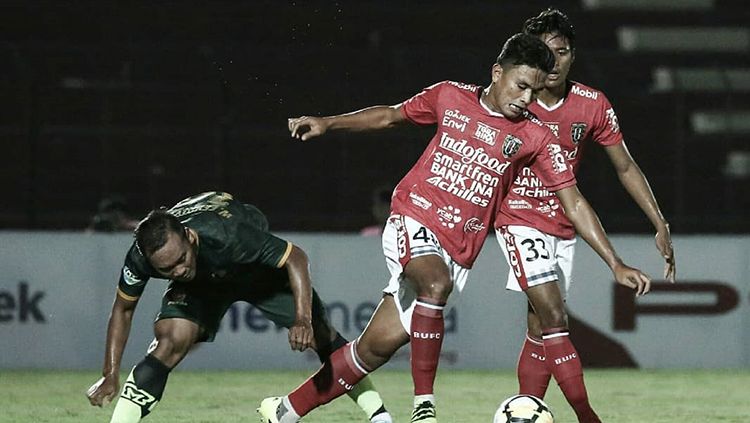 Ahmad Agung (depan) berhasil melewati pemain PS TIRA. Copyright: © Bali United