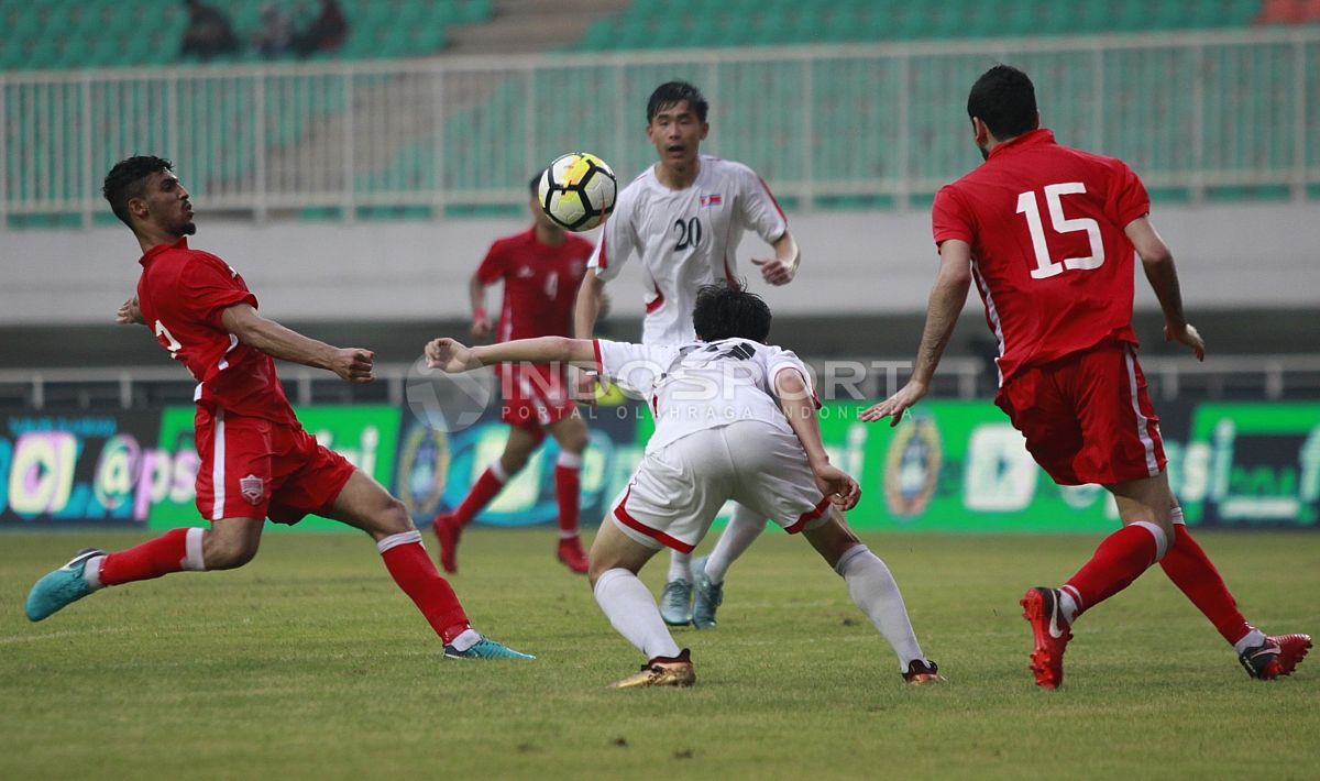 Perebutan bola antara pemain Korea Utara dengan pemain Bahrain. Herry Ibrahim Copyright: © Herry Ibrahim/INDOSPORT