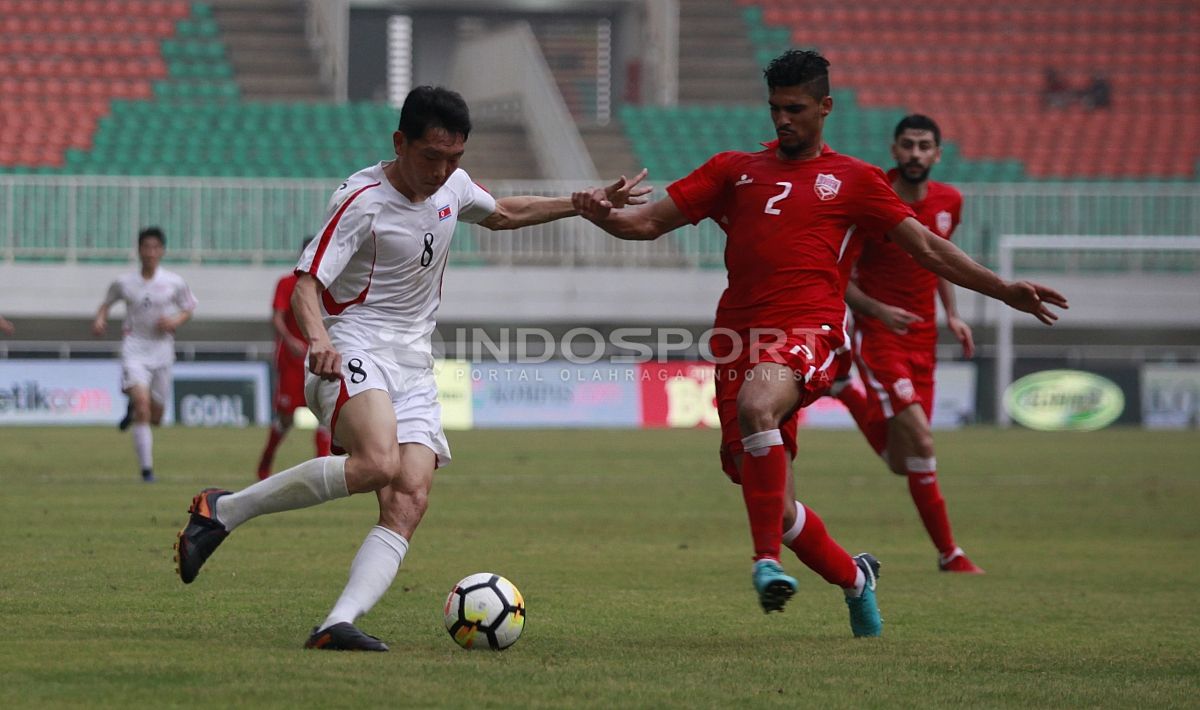 Duel antara pemain Korea Utara, Jong Kum Song dengan pemain Bahrain, Sayed Mohamed Shubbar. Herry Ibrahim Copyright: © Herry Ibrahim/INDOSPORT