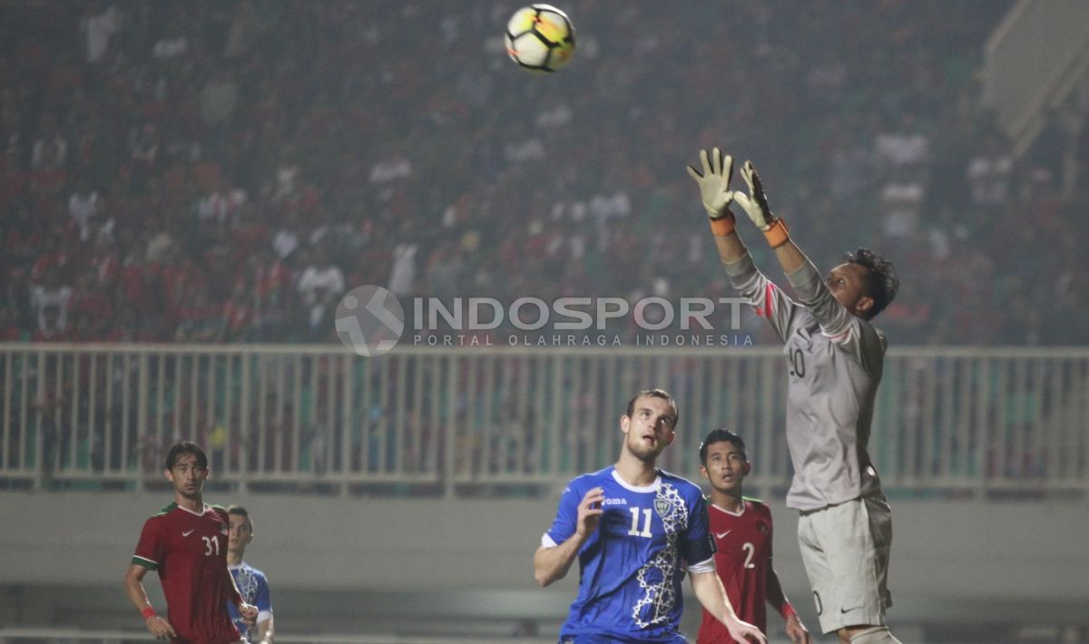 Kiper Indonesia, Awan Setho mengamankan bola dari serangan Uzbekistan. Herry Ibrahim Copyright: © Herry Ibrahim/INDOSPORT