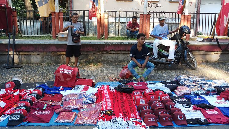 Pedagan atribut PSM Makassar, Hamdjah (kaos abu-abu) di sekitaran Stadion Andi Mattalatta Mattoangin. Copyright: © Wira Wahyu Utama/INDOSPORT