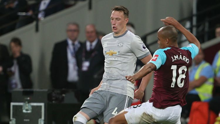 Phil Jones kala berduel dengan pemain West Ham. Copyright: © INDOSPORT