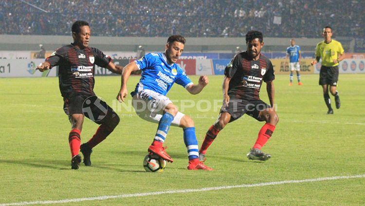 Jonathan Bauman (tengah) dalam pengawalan ketat dua pemain Persipura. Copyright: © Arif Rahman/INDOSPORT