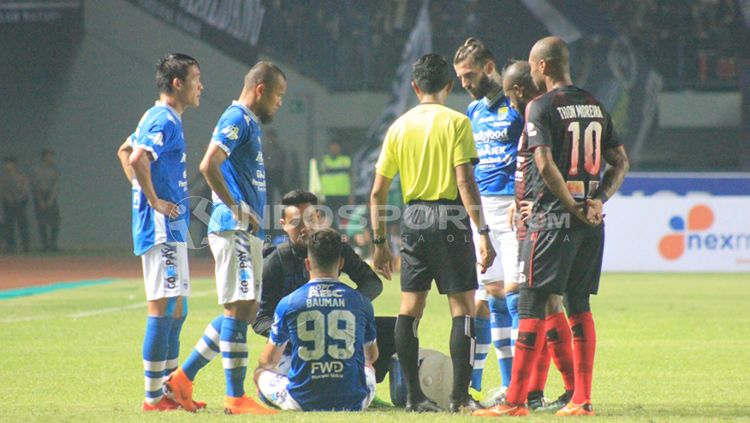 Jonathan Bauman menerima perawatan ringan di dalam lapangan. Copyright: © Arif Rahman/INDOSPORT