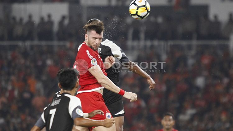 Marko Simic berduel udara dengan pemain Home United. Copyright: © Herry Ibrahim/INDOSPORT