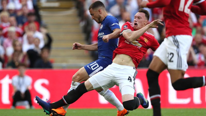 Phil Jones melakukan pelanggaran kepada Eden Hazard. Copyright: © INDOSPORT