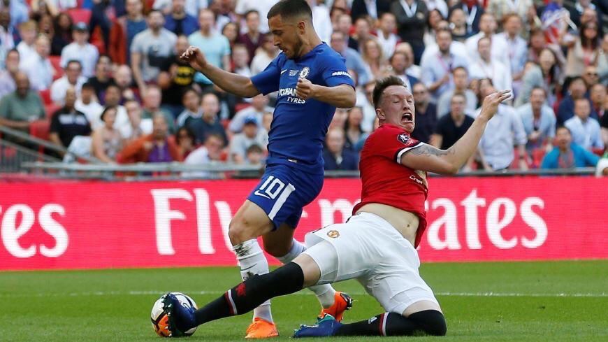 Phil Jones melakukan pelanggaran kepada Eden Hazard. Copyright: © INDOSPORT