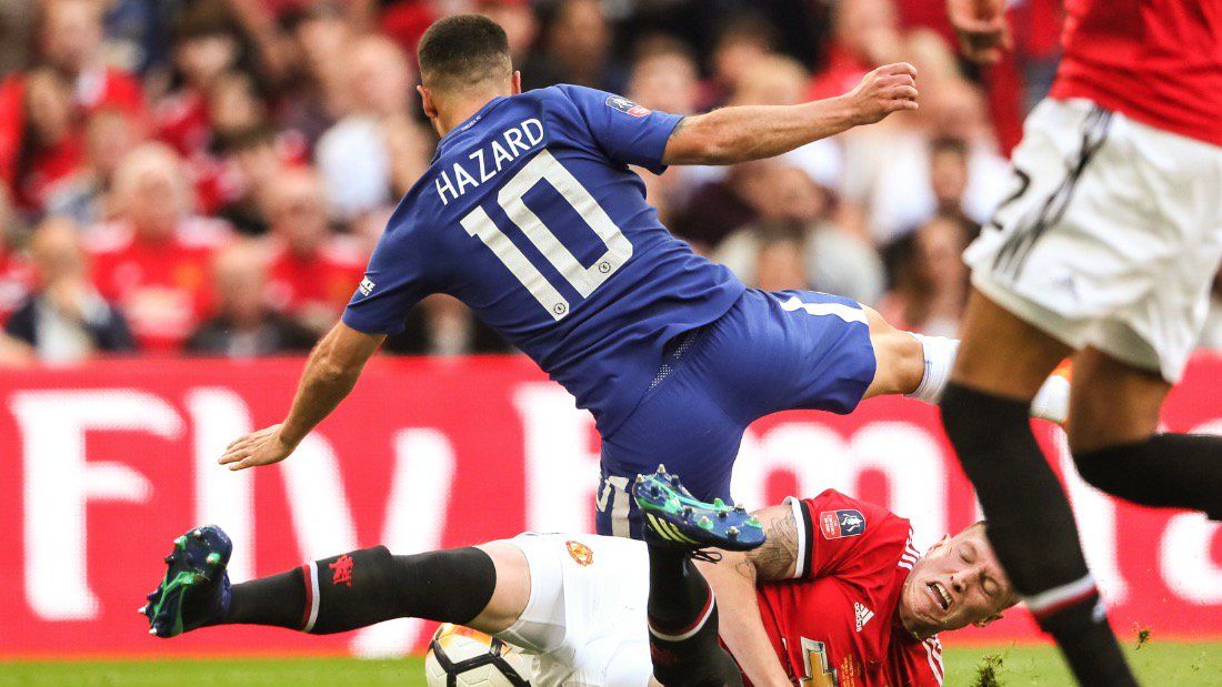 Phil Jones melakukan pelanggaran kepada Eden Hazard. Copyright: © INDOSPORT