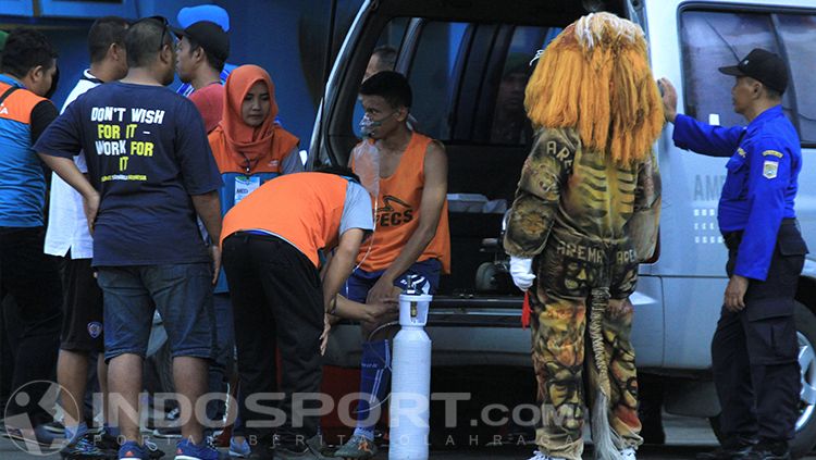Rivaldi Bauwo mendapat perawatan intensif tim medis dalam laga Arema vs PSM. Copyright: © INDOSPORT/Ian Setiawan