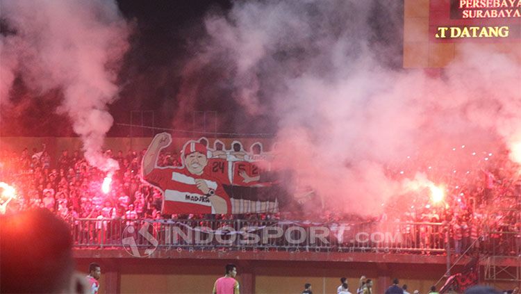 Suporter Madura United menyalakan flare. Copyright: © INDOSPORT/Fitra Herdian