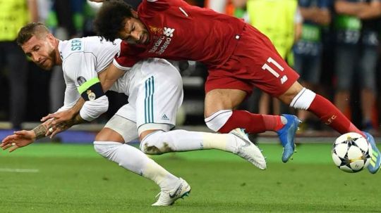 Sergio Ramos meraik tangan Mohamed Salah. Copyright: © Getty Images