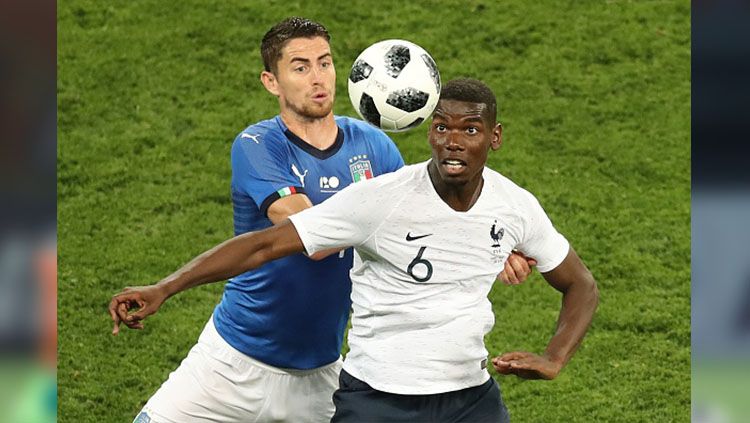 Paul Pogba berebut bola dengan gelandang Italia, Jorginho. Copyright: © VALERY HACHE/AFP/Getty Images