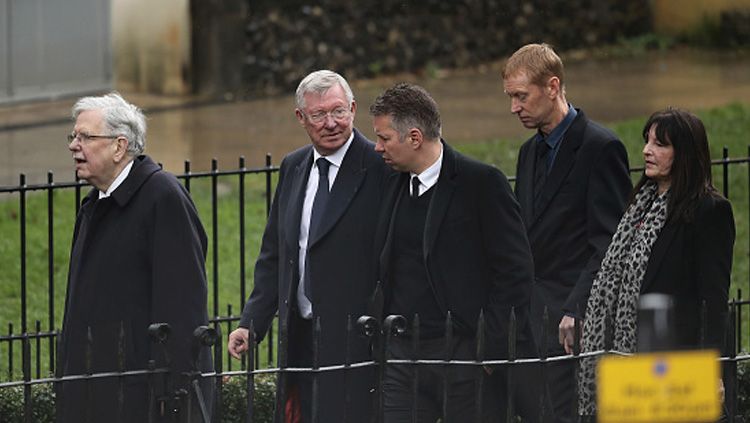 Sir Alex Ferguson (kedua dari kiri) saat berjalan dengan anggota keluarganya dalam sebuah acara pada beberapa hari yang lalu. Copyright: © INDOSPORT