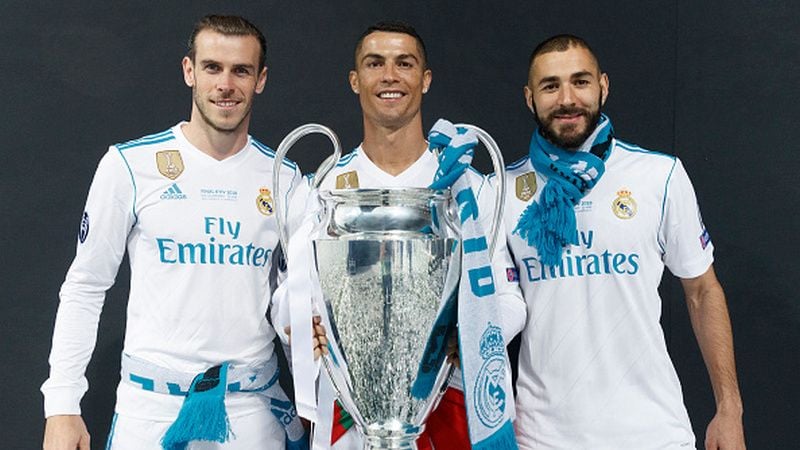 Gareth Bale, Cristiano Ronaldo, dan Karim Benzema memegang trofi Liga Champions. Copyright: © Getty Images
