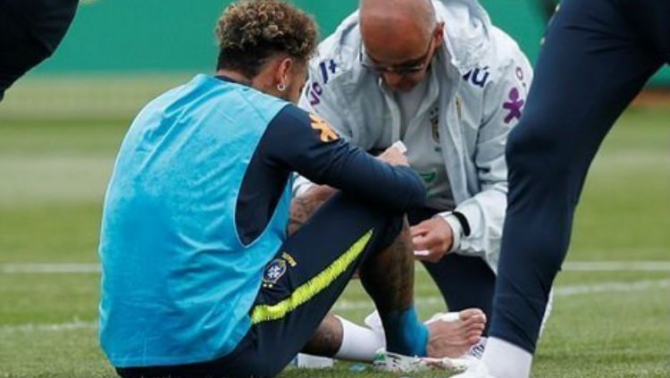 Neymar saat mendapat perawatan dari tim medis. Copyright: © AFP
