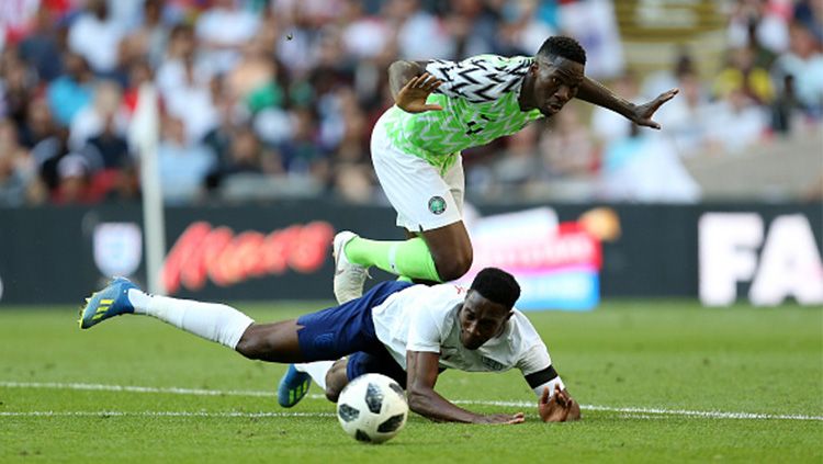 Kyle Walker (bawah) berusaha memblok bola hasil dribel Victor Moses dalam laga persahabatan Inggris vs Nigeria.  Copyright: © Getty Images