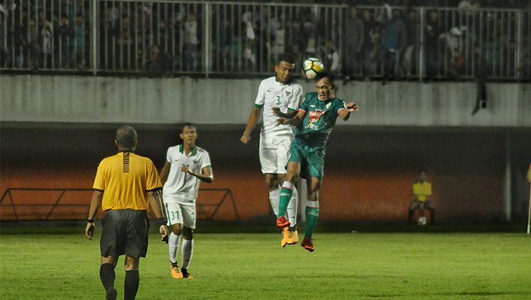 Bek Timnas U-19, Julyano Pratama Nono (kiri), berduel udara dengan pemain PSS Sleman. Copyright: © PSSI