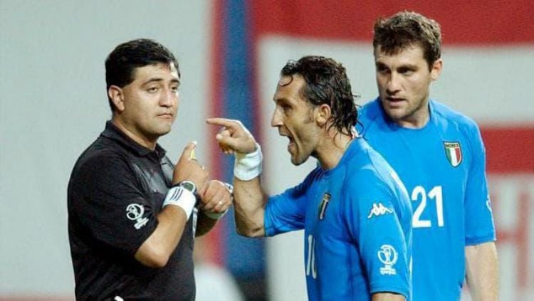 Byron Moreno berdebat dengan Angelo Di Livio kala memberi pelanggaran pada Fransesco Totti di Piala Dunia 2002. Copyright: © The Australian