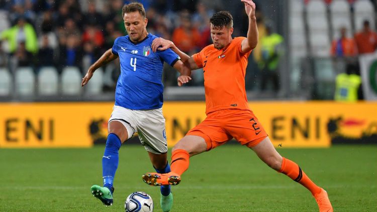 Domenico Criscito berebut bola dengan Hans Hateboer saat laga Italia vs Belanda Copyright: © twitter.com/azzurri