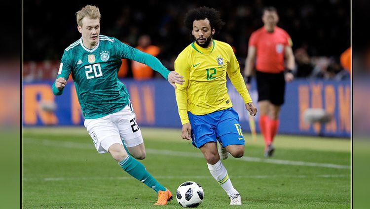 Julian Brandt (kiri/gelandang serang Jerman) saat berduel dengan bek kiri Timnas Brasil, Marcelo. Copyright: © Getty Images