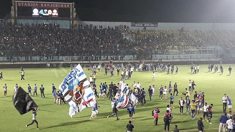 Invasi Aremania ke lapangan pasca laga kontra Bhayangkara FC berbuntut sanksi denda. Copyright: © Ian Setiawan/INDOSPORT