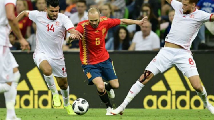 Andres Iniesta saat membawa bola mendapat gangguan dari pemain Tunisia. Copyright: © Getty Images