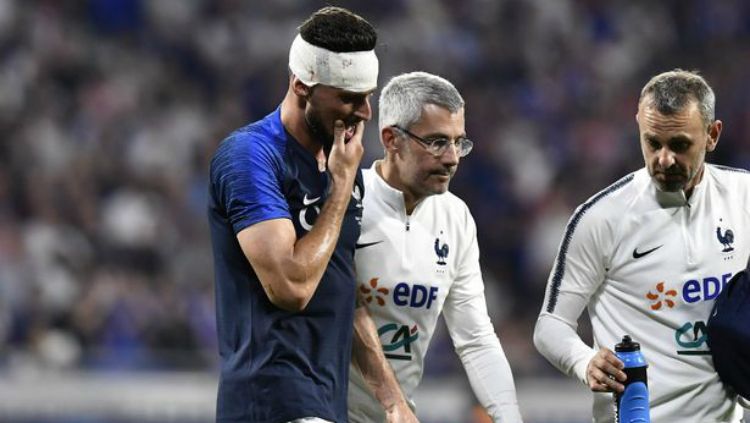 Olivier Giroud harus diperban kepalanya usai tubrukan dengan Matt Miazga dalam laga Prancis vs AS jelang Piala Dunia 2018. Copyright: © AFP